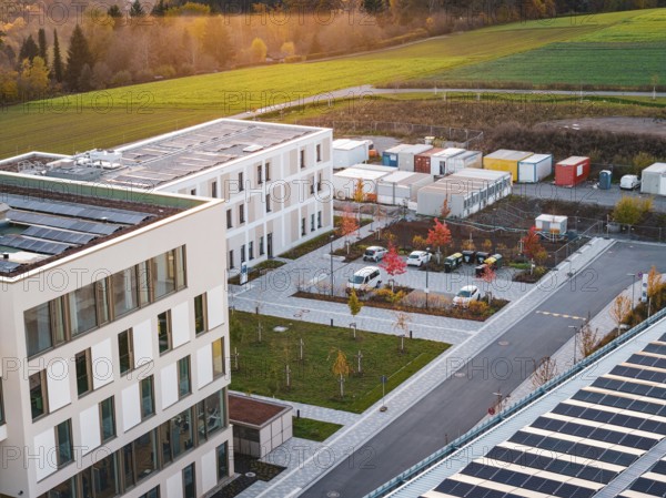 Campus with office buildings and colorful autumn trees next to a container area, new hospital, Calw health campus, Black Forest, Germany