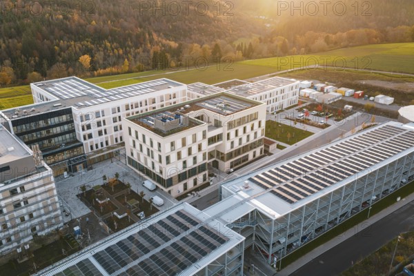 Modern buildings with solar panels on the roof, surrounded by landscape at sunset, new hospital, Calw Health Campus, Black Forest, Germany