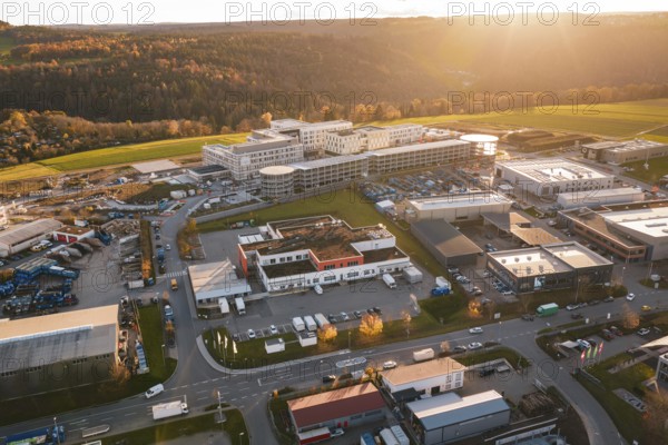 Large building complex with surrounding industrial areas in autumn landscape at sunset, new hospital, Calw health campus, Black Forest, Germany