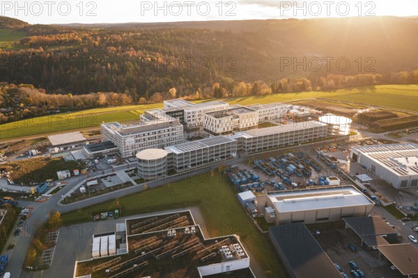 Aerial view of a large complex of buildings in autumn landscape at sunset, new hospital, Calw Health Campus, Black Forest, Germany