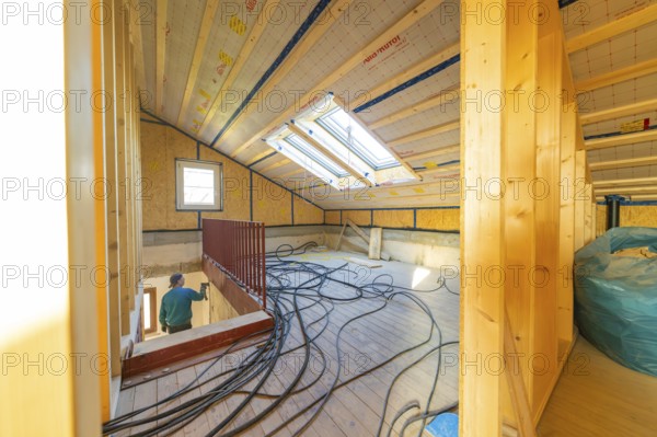 Top floor during renovation with cable harnesses and skylights that illuminate the room