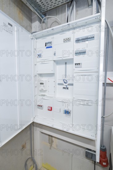 Open electrical cabinet with various control boxes in a technical room