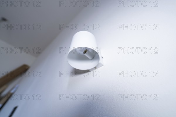 A modern white wall lamp on the wall