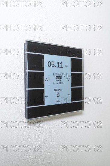 A modern switch on the wall with a blue display