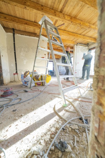 A ladder and tools on a construction site with a wooden ceiling