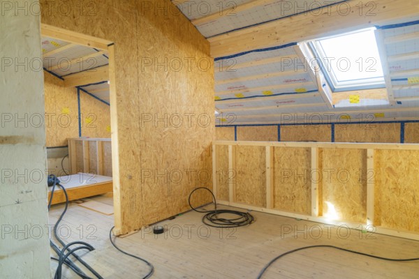 A bright attic room under construction with wooden lining