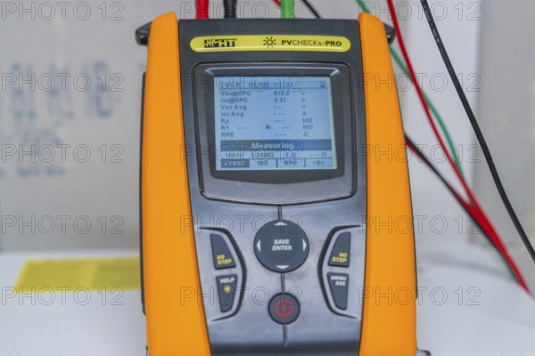 Measuring device with cables shows various electrical measurements on a display