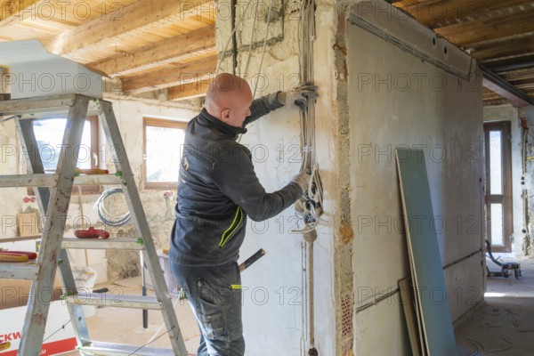 A worker installs cables on a construction site