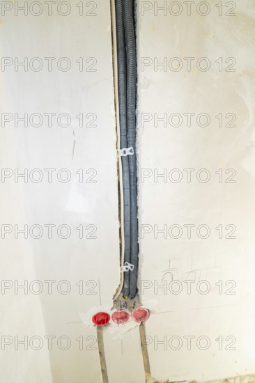 Black cable ducts inserted into the wall, prepared for electrical installation