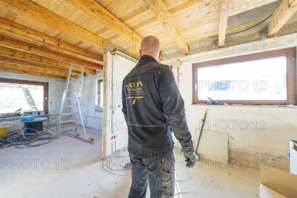 Person working in an attic lit with daylight during renovation