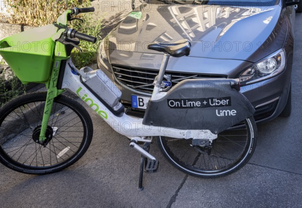 Lime rental bike stands obstructively in front of a car on public roads, Berlin, Germany