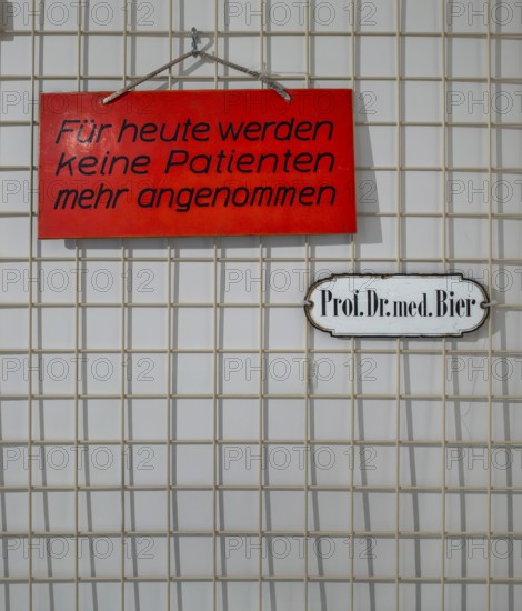Information signs on a small metal grid in front of a doctor's office, Berlin, Germany