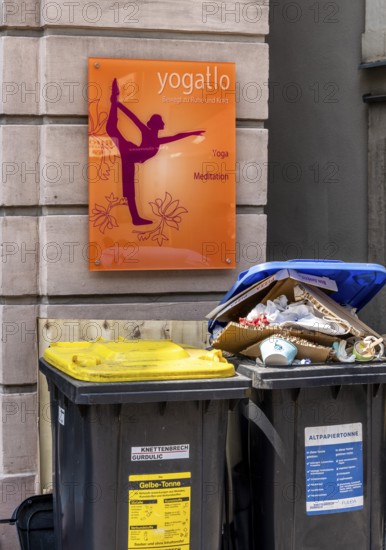 Overfilled trash cans at the entrance to a yoga school, Fulda, Hesse, Germany
