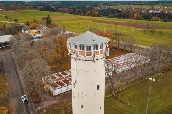 Water tower in rural autumn landscape with trees and small buildings in the village, water tower, Pfalzgrafenweiler, Freudenstadt district, Germany