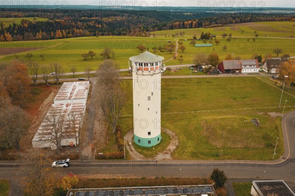 Water tower in the middle of a vast landscape with fields and small buildings in the background, water tower, Pfalzgrafenweiler, Freudenstadt district, Germany