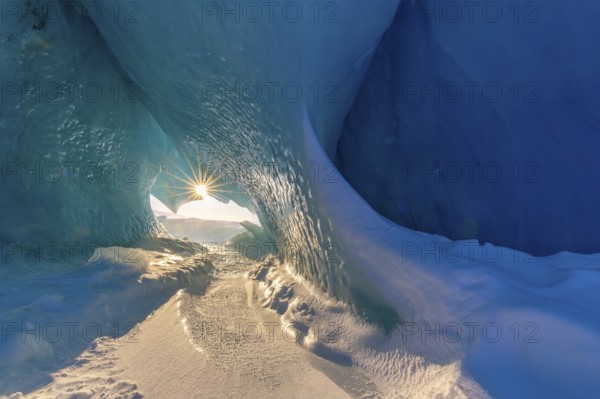 Midnight sun shining in glacial ice cave at Mohnbukta, bay at western shore of Storfjorden in Sabine Land, Spitsbergen, Svalbard