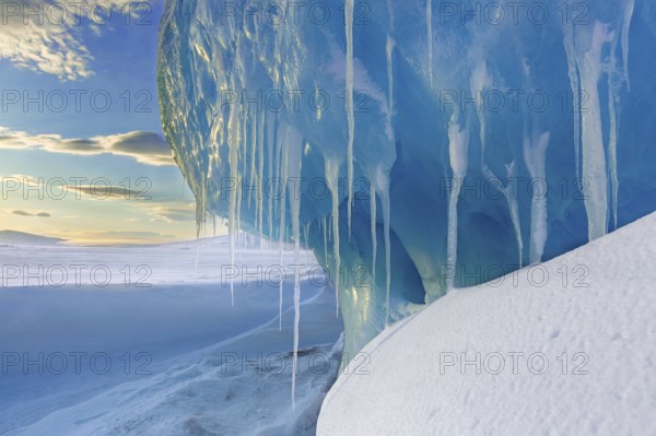 Melting icicles in snow covered Arctic landscape at Mohnbukta, bay at the western shore of Storfjorden in Sabine Land at Spitsbergen, Svalbard