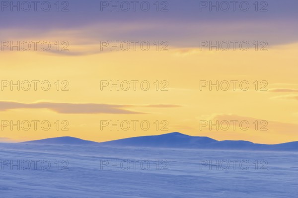 Snow covered mountains at midnight in Arctic landscape at Mohnbukta, bay at the western shore of Storfjorden in Sabine Land at Spitsbergen, Svalbard
