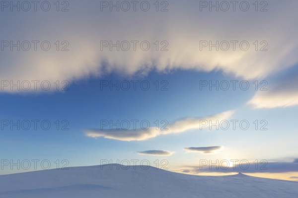 Stratus cloud rolling in over snow covered Arctic landscape at Mohnbukta, bay at western shore of Storfjorden in Sabine Land, Spitsbergen, Svalbard