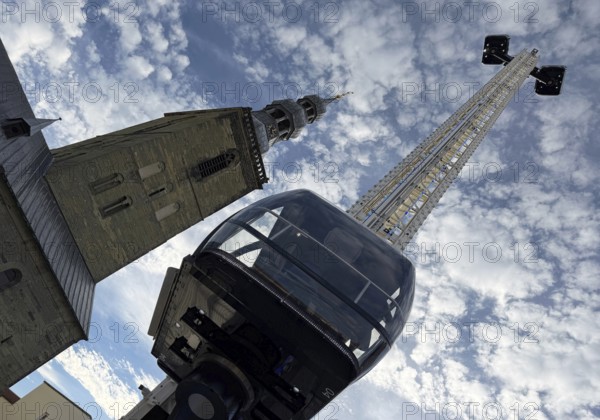 View from bottom to top of the Look 360 degree mobile skylift and of St. Peter's Church, All Saints Fair, Soest, North Rhine-Westphalia, Germany