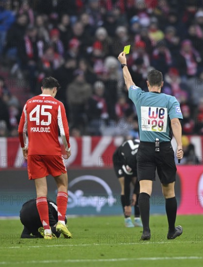 Referee Sven Jablonski showing Aleksandar Pavlovic FC Bayern Munich FCB (45) yellow card yellow card warning Allianz Arena, Munich, Bayern, Germany