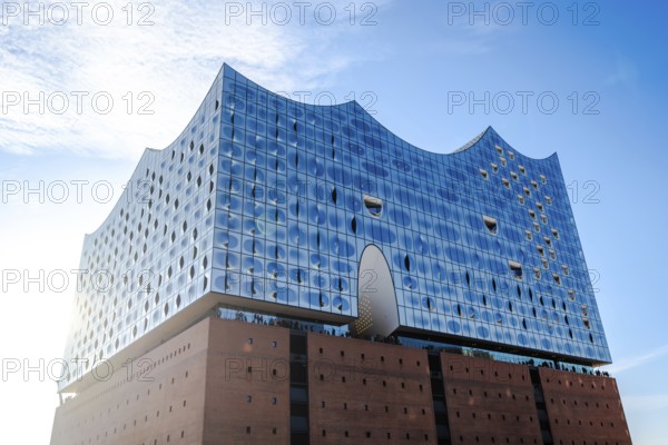The modern Elbe Philharmonic Hall with its unique glass façade rises majestically against the blue sky in Hamburg, Hamburg, Germany