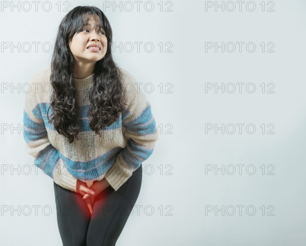 Medical problem urinary incontinence. Asian young woman with urinary problems, Female with hands on crotch with urinary problems