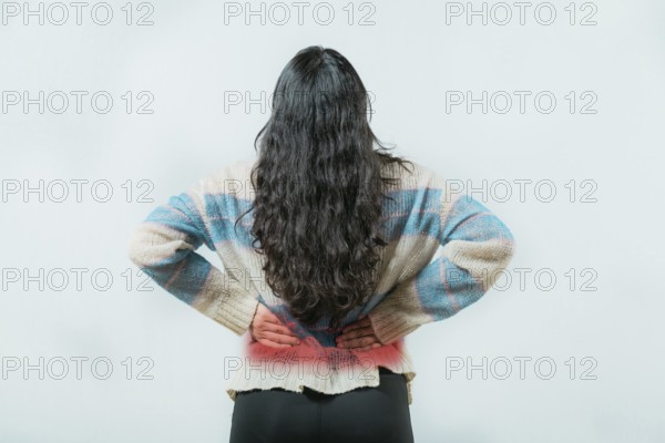 Suffering young woman with pain holding his back isolated. Female with spine problems isolated. Lumbar problems. woman with pain holding his back