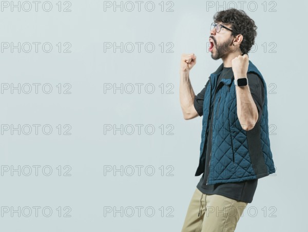 Happy guy with sunglass celebrating something. Excited young man celebrating looking at camera raising arms isolated