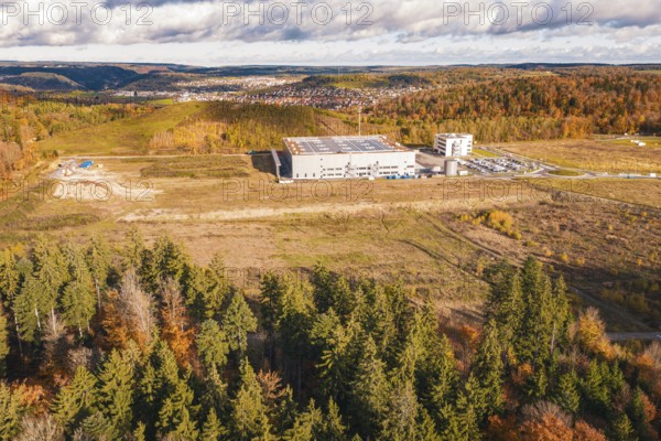 Large industrial complex in autumn, nestled in a hilly landscape, new Lindenrain industrial park, Calw, Black Forest, Germany
