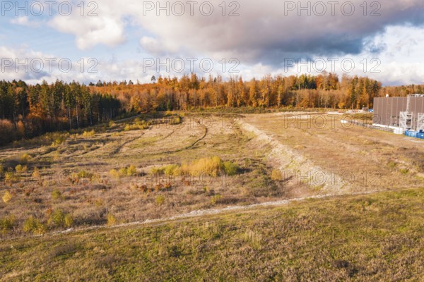 Open autumn landscape with wooded areas and dramatic skies, new Lindenrain industrial park, Calw, Black Forest, Germany