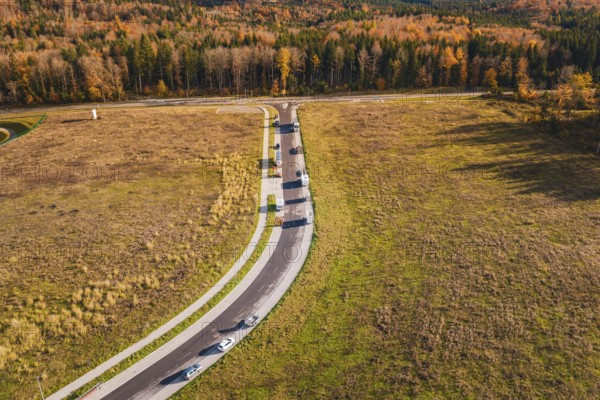 Intersection with moving cars in an open autumn landscape, new Lindenrain industrial park, Calw, Black Forest, Germany