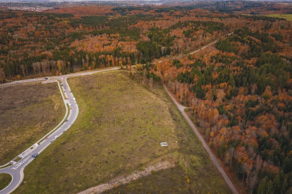 Wide fields and autumn forests criss-crossed by paths and roads, new Lindenrain industrial park, Calw, Black Forest, Germany