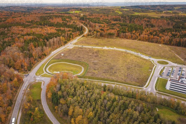 Landscape with road junction and surrounding autumnal forests and open fields, new Lindenrain industrial park, Calw, Black Forest, Germany