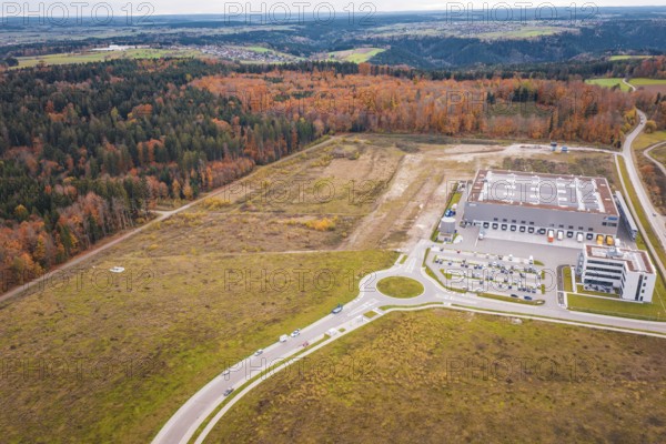 Industrial area with modern building on the edge of the forest and autumn landscape, new Lindenrain industrial park, Calw, Black Forest, Germany
