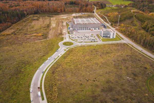 Industrial plant with surrounding roads and parking areas in an autumn landscape, new Lindenrain industrial park, Calw, Black Forest, Germany