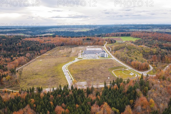 Industrial plant surrounded by extensive autumn landscape with forests and roads, new Lindenrain industrial park, Calw, Black Forest, Germany