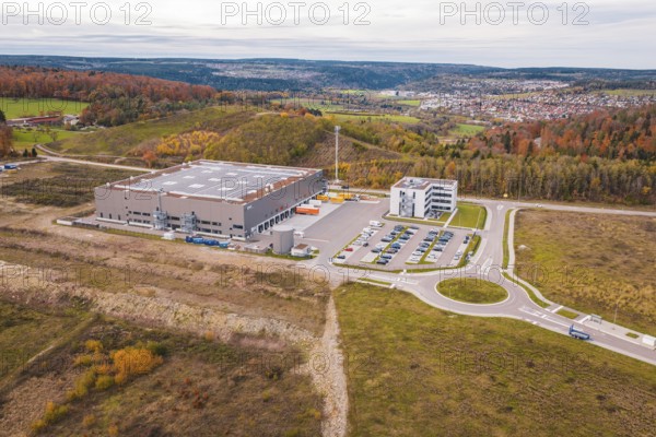 Industrial building with parking spaces in autumn hills, new Lindenrain industrial park, Calw, Black Forest, Germany