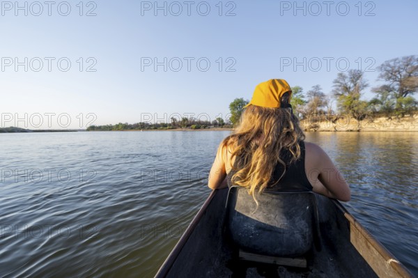 Tourists in a Mokoro, dugout boat on the Okavango River, Caprivi Strip, Namibia