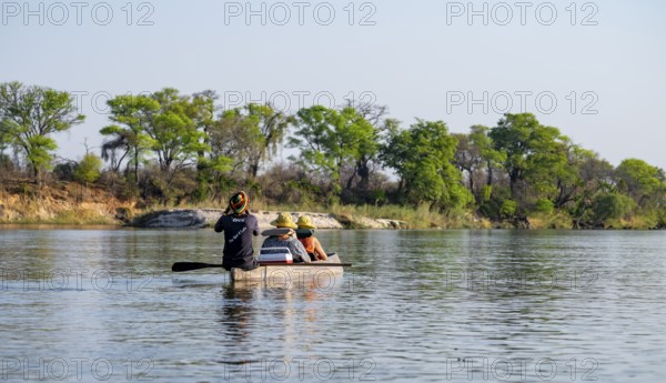 Boat trip, tourists in a Mokoro, dugout boat on the Okavango River, Caprivi Strip, Namibia