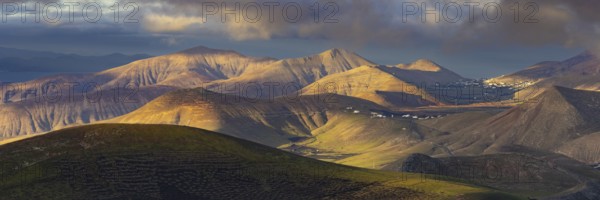 La Geria wine region, behind the volcanic formation Los Ajaches at sunrise, Lanzarote, Canary Islands, Spain