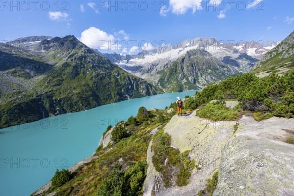 Mountaineers in front of picturesque mountain landscape, turquoise-blue mountain lake Göscheneralpsee, Dammastock and Damma Glacier, Göscheneralp, Canton of Uri, Switzerland