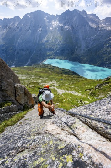 Mountaineer climbs on the secured Schijen-Zwärg via ferrata, climb to Bergseehütte, Göscheneralp in the back, Canton of Uri, Switzerland