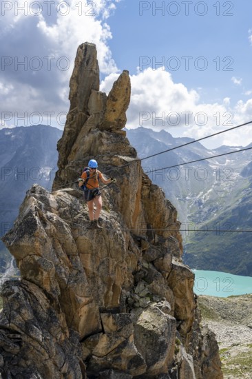 Crocodile rock formation, mountaineer on rope bridge in the Crocodile Mountain Lake via ferrata on Bergseeschijen-Vorbau, Göscheneralp, Canton of Uri, Switzerland