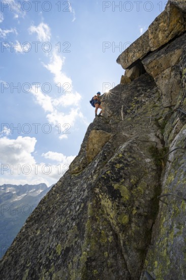 Female mountaineer on steep rock face on the secured via ferrata Krokodil-Bergsee am Bergseeschijen-Vorbau, Sonnenstern, Göscheneralp, Canton of Uri, Switzerland