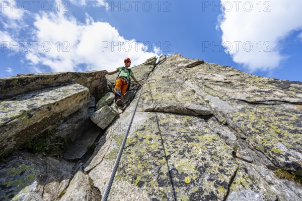 Mountaineers on steep rock face in the secured via ferrata Crocodile Mountain Lake at Bergseeschijen-Vorbau, Göscheneralp, Canton of Uri, Switzerland