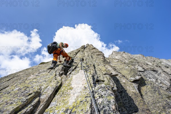 Mountaineers on the secure via ferrata Crocodile Mountain Lake at Bergseeschijen-Vorbau, Göscheneralp, Canton of Uri, Switzerland