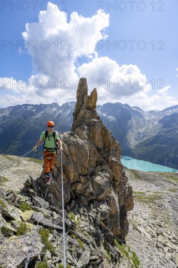Crocodile rock formation, mountaineer on rope bridge in the Crocodile Mountain Lake via ferrata on Bergseeschijen-Vorbau, Göscheneralp, Canton of Uri, Switzerland