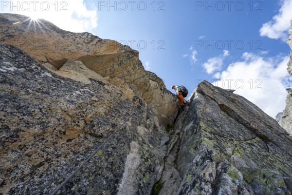 Mountaineers on steep rock face in the secured via ferrata Crocodile Mountain Lake at Bergseeschijen-Vorbau, Sonnenstern, Göscheneralp, Canton of Uri, Switzerland