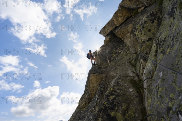 Female mountaineer on steep rock face on the secured via ferrata Krokodil-Bergsee am Bergseeschijen-Vorbau, Sonnenstern, Göscheneralp, Canton of Uri, Switzerland
